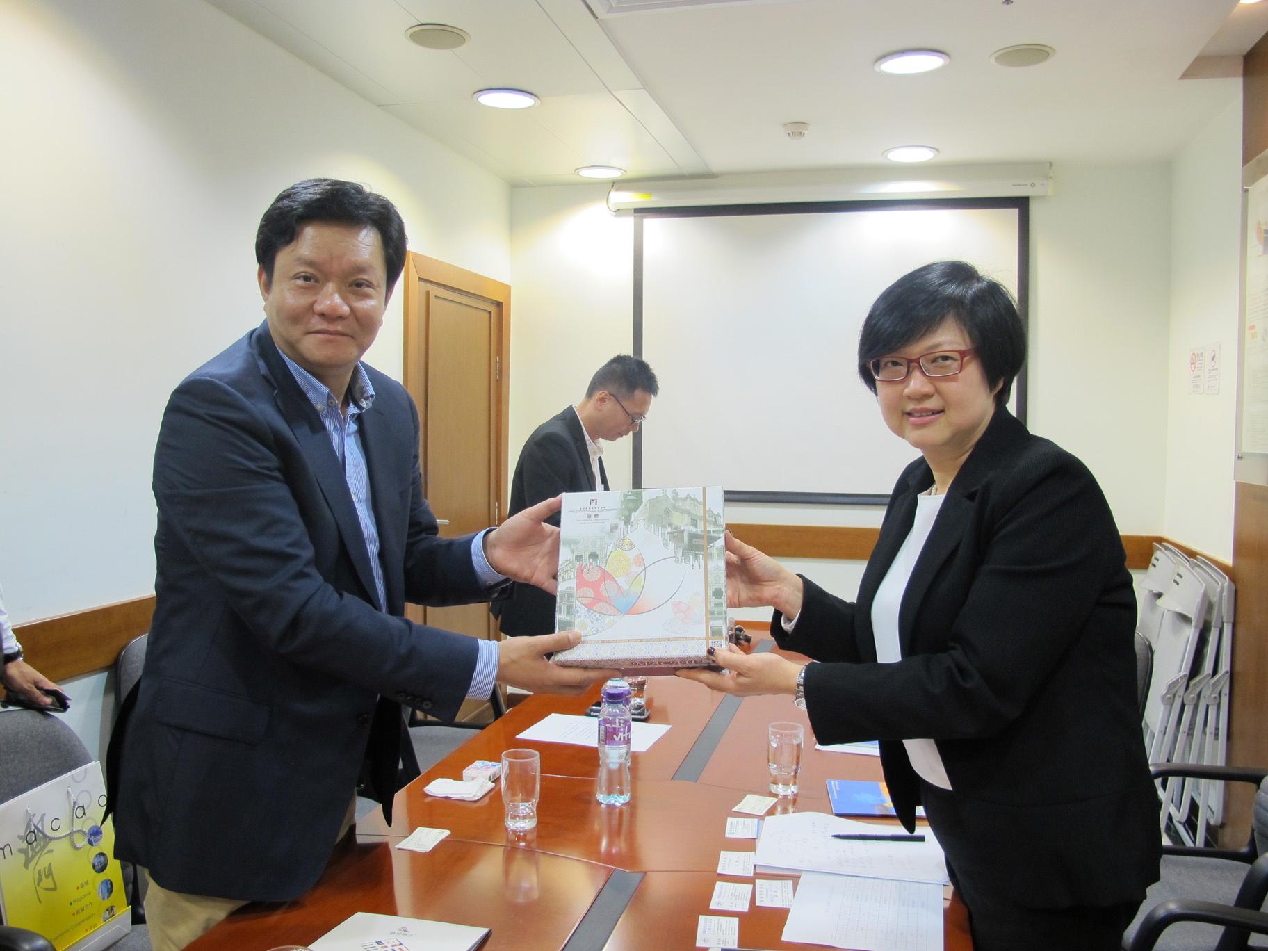 吴爱华执行委员向到访本局的海南省商务厅副厅长姚磊致送纪念品 (2016年3月3日)